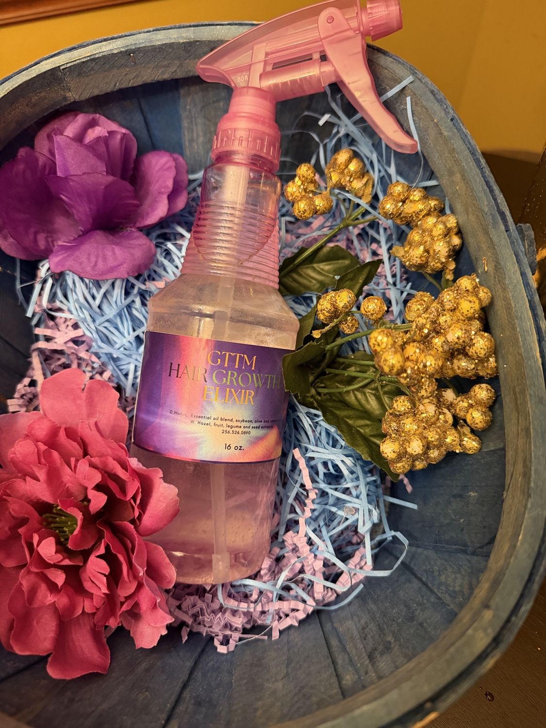 GTTM Hair Growth Elixir bottle styled with flowers